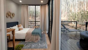 Een slaapkamer met een bed, nachtkastje en uitzicht op de omgeving.
