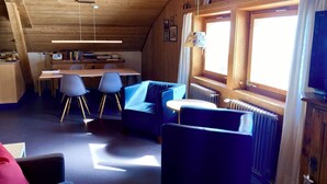A cozy cabin interior with a dining area, a sofa, and a television. - Chasa Soldanella, (Tarasp) by Interhome (Tarasp)