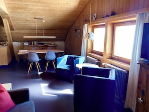 A cozy cabin interior with a dining area, a sofa, and a television. - Chasa Soldanella, (Tarasp) by Interhome (Tarasp)
