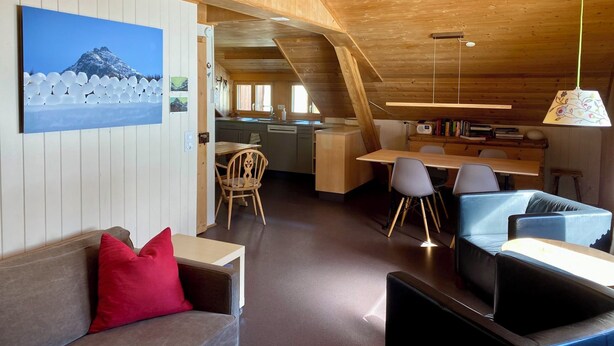 A cozy cabin interior with a dining area, kitchen, and seating space. - Chasa Soldanella, (Tarasp) by Interhome (Tarasp)