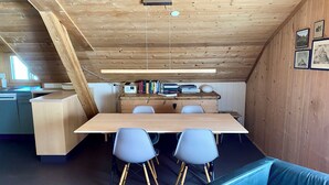 A room with a wooden ceiling, a desk with books, a computer, and two chairs. - Chasa Soldanella, (Tarasp) by Interhome (Tarasp)