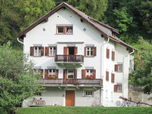 Ein mehrstöckiges Gebäude mit Balkon, einer Tür und einem Fenster.