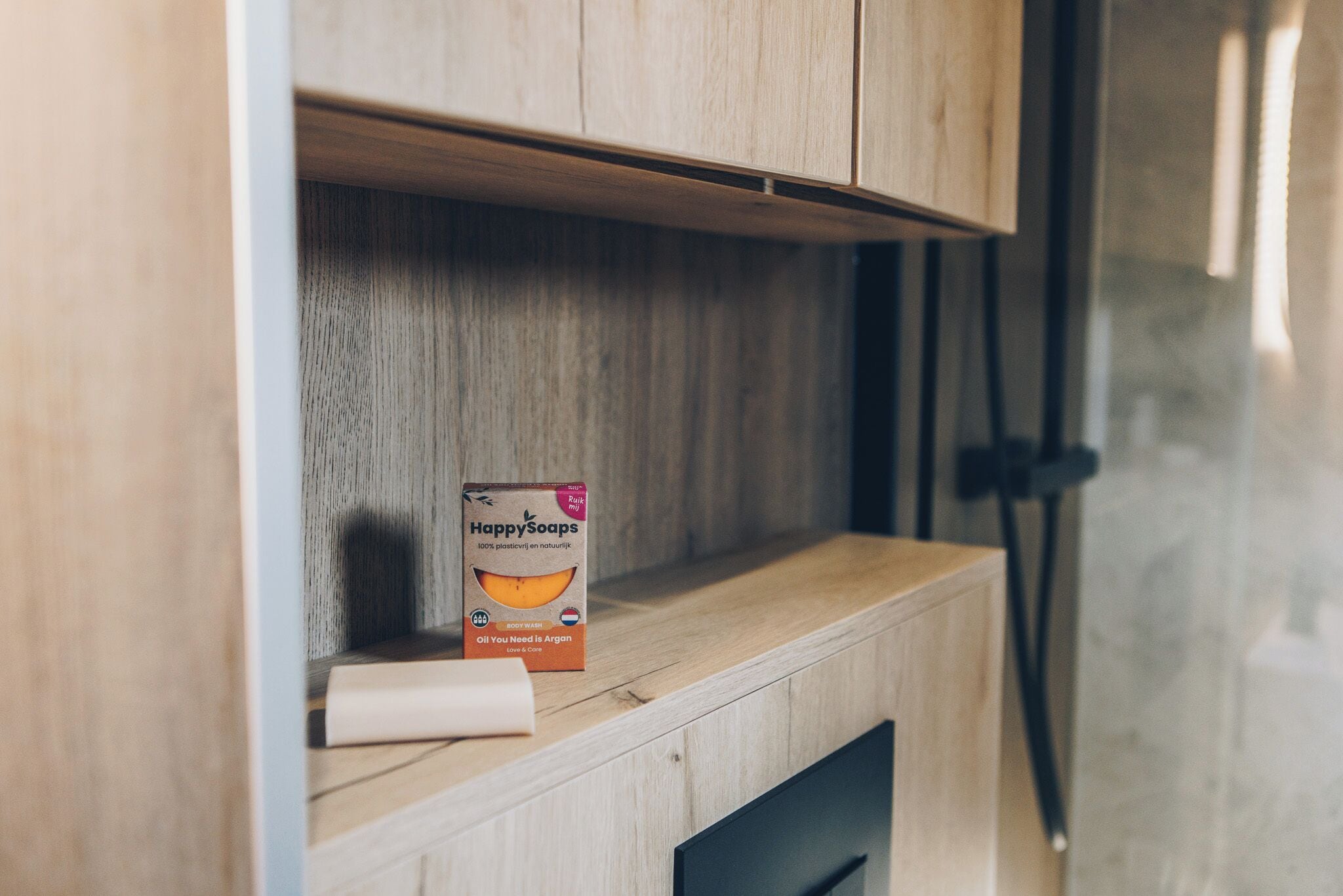 Une étagère en bois sur laquelle se trouve une boîte de savons de la marque Happy Soaps.