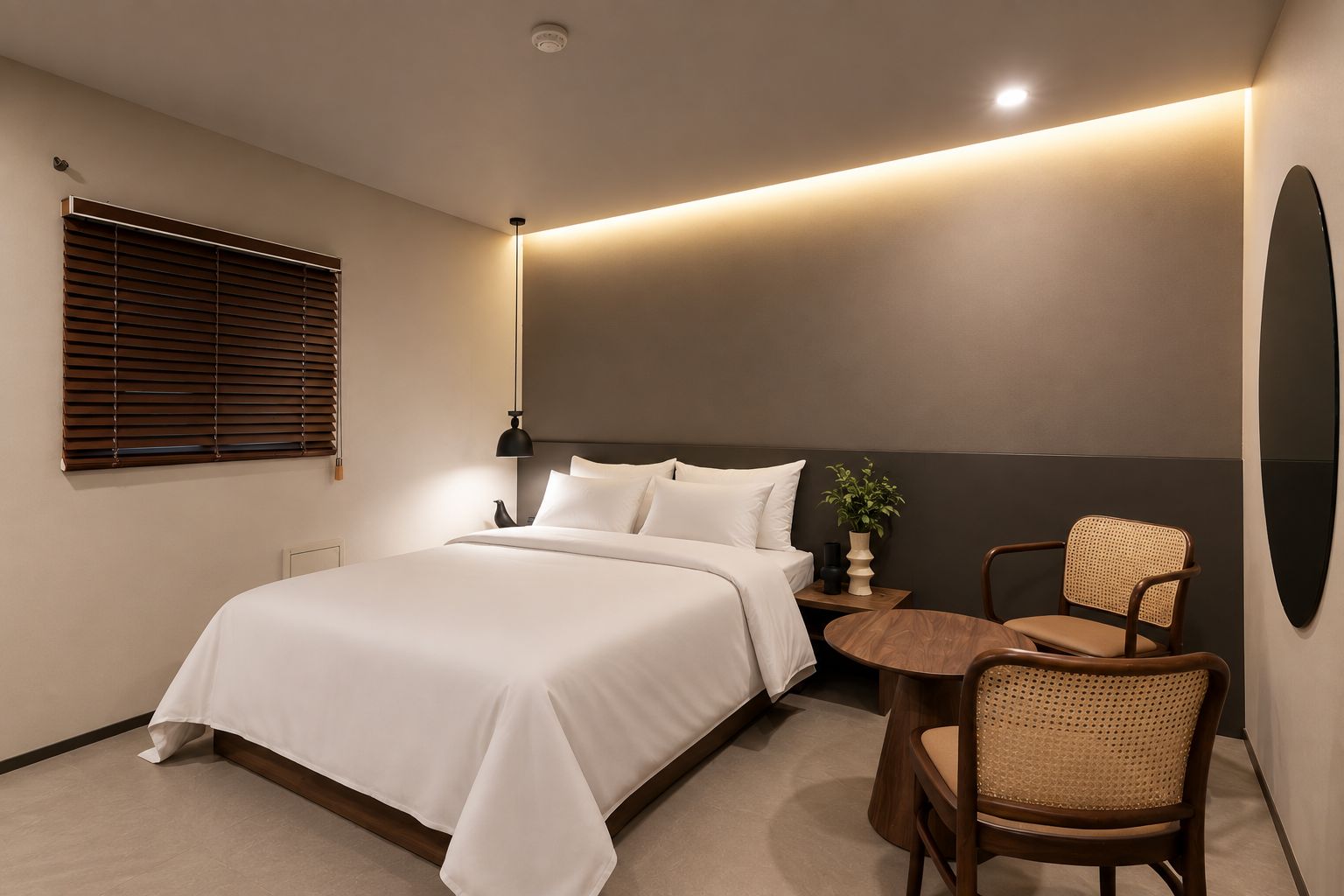 Ein modernes Hotelzimmer mit Bett, Nachttisch, Lampe, Stuhl und einem wandmontierten Spiegel.