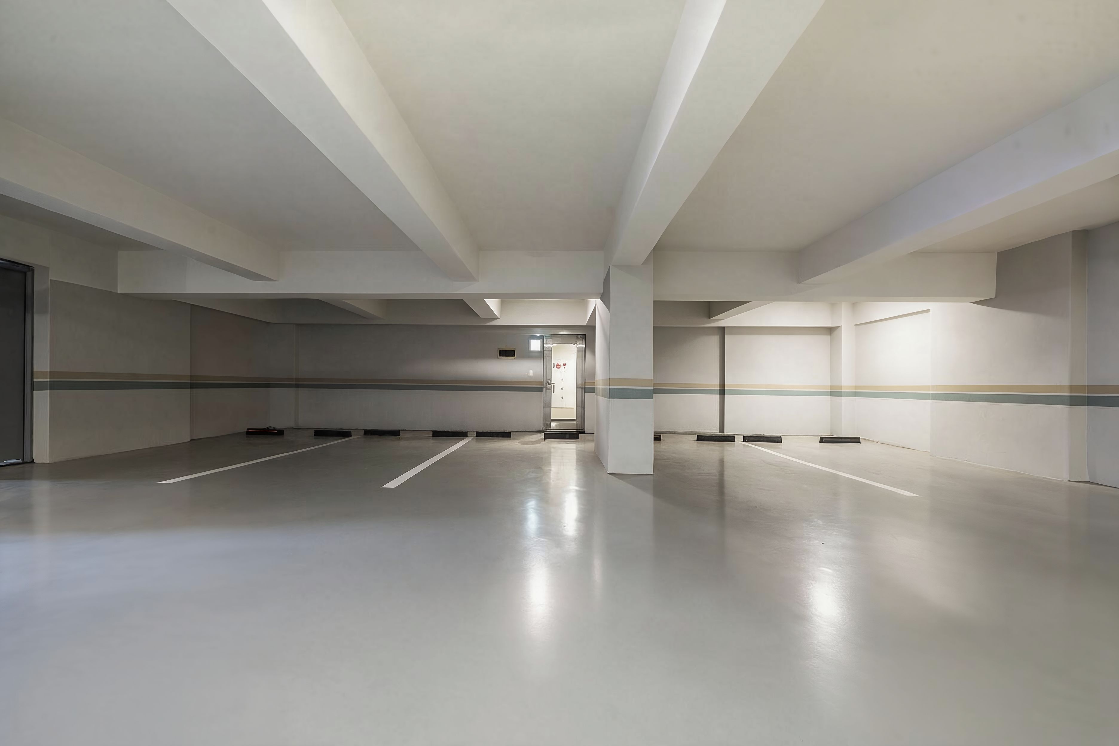A spacious, empty parking garage with a clean, modern design and a clear path leading to an exit.