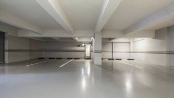A spacious, empty parking garage with a clean, modern design and a clear path leading to an exit.