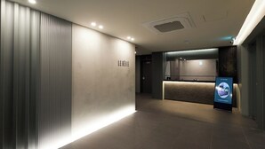 Una zona de recepción moderna con mostrador, señalización en la pared y suelo de baldosas.