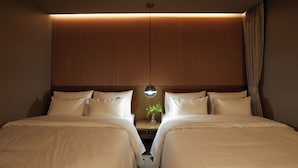 A hotel room with two beds, a nightstand with a vase, and a mirror on the wall. - Lereve Hotel (Seoul)