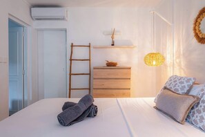 Ein Schlafzimmer mit einem Bett, einem Holzschrank, einer Himmelsleiter, einem Wandregal und einer Pendelleuchte.