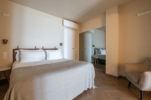 A hotel room with a bed, a chair, a small table, and a mirror. - Lbb1 (Lisbon)