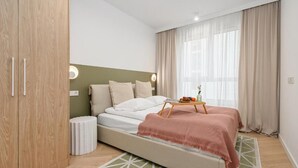 Ein Schlafzimmer mit einem Bett, Nachttischen, einem Kleiderschrank und einem Fenster mit Vorhängen.