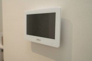 Ein weißer Thermostat an einer Wand befestigt.