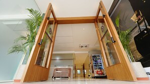 Ein Hotel Eingang mit Holzrahmen, Glasscheiben und Blumentöpfen.