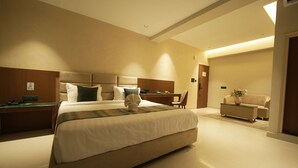 Ein modernes Hotelzimmer mit einem großen Bett, einem Schreibtisch und einer Sitzecke.