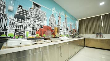 Une cuisine moderne agrémentée d’une fresque représentant un paysage urbain, d’appareils électroménagers en acier inoxydable et d’un buffet.