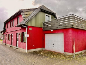 Ein rotes Gebäude mit Garage, Hinweisschild mit der Nummer 67 und einem Schild für Privateigentum.