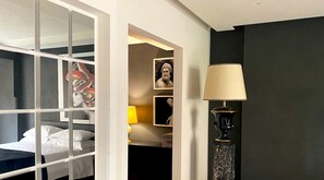Ein Zimmer mit einem Etagenbett, einer Lampe, gerahmten Kunstwerken und einer dunklen Wand.