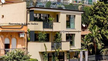 Un edificio a più piani con balconi, mobili da esterno e piante in vaso.