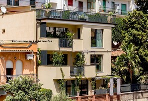 Un edificio a più piani con balconi, mobili da esterno e piante in vaso.