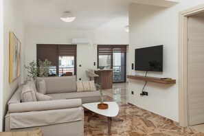 Ein modernes Wohnzimmer mit einer Couch, einem Couchtisch, einem Fernseher und einem Balkon.