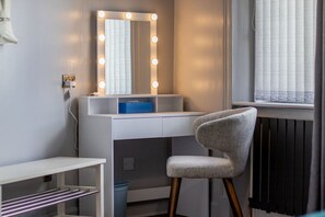 Ein modernes Zimmer mit Schminktisch, Spiegel und Stuhl.