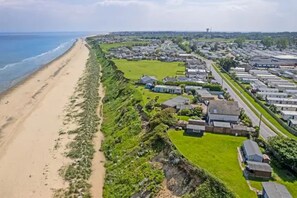 Une zone résidentielle côtière comprenant des maisons, une plage et une route.
