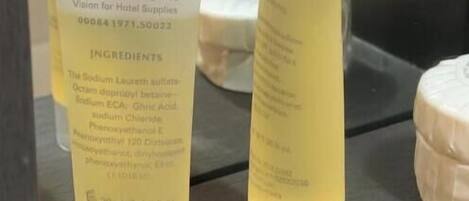 Two tubes of a skincare product with visible ingredients and a label indicating it is distributed by Integrated Vision for Hotel Supplies.