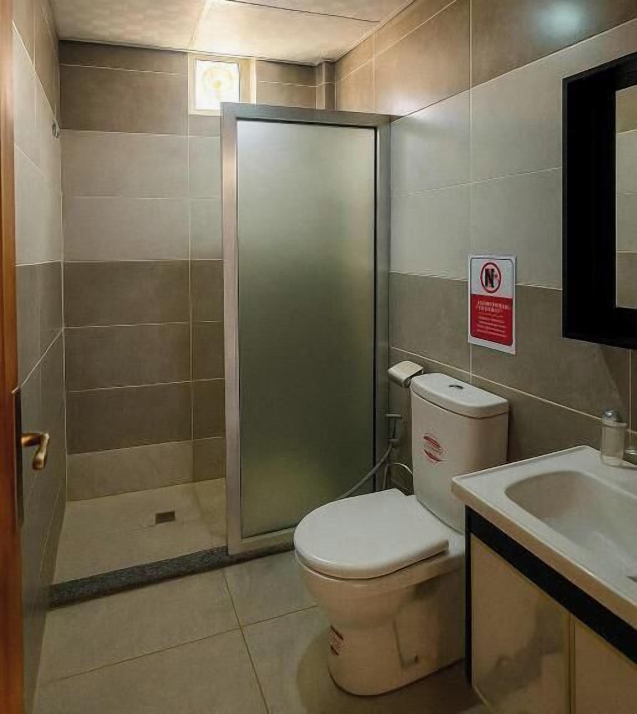 A bathroom with a toilet, a sink, and a shower enclosure.