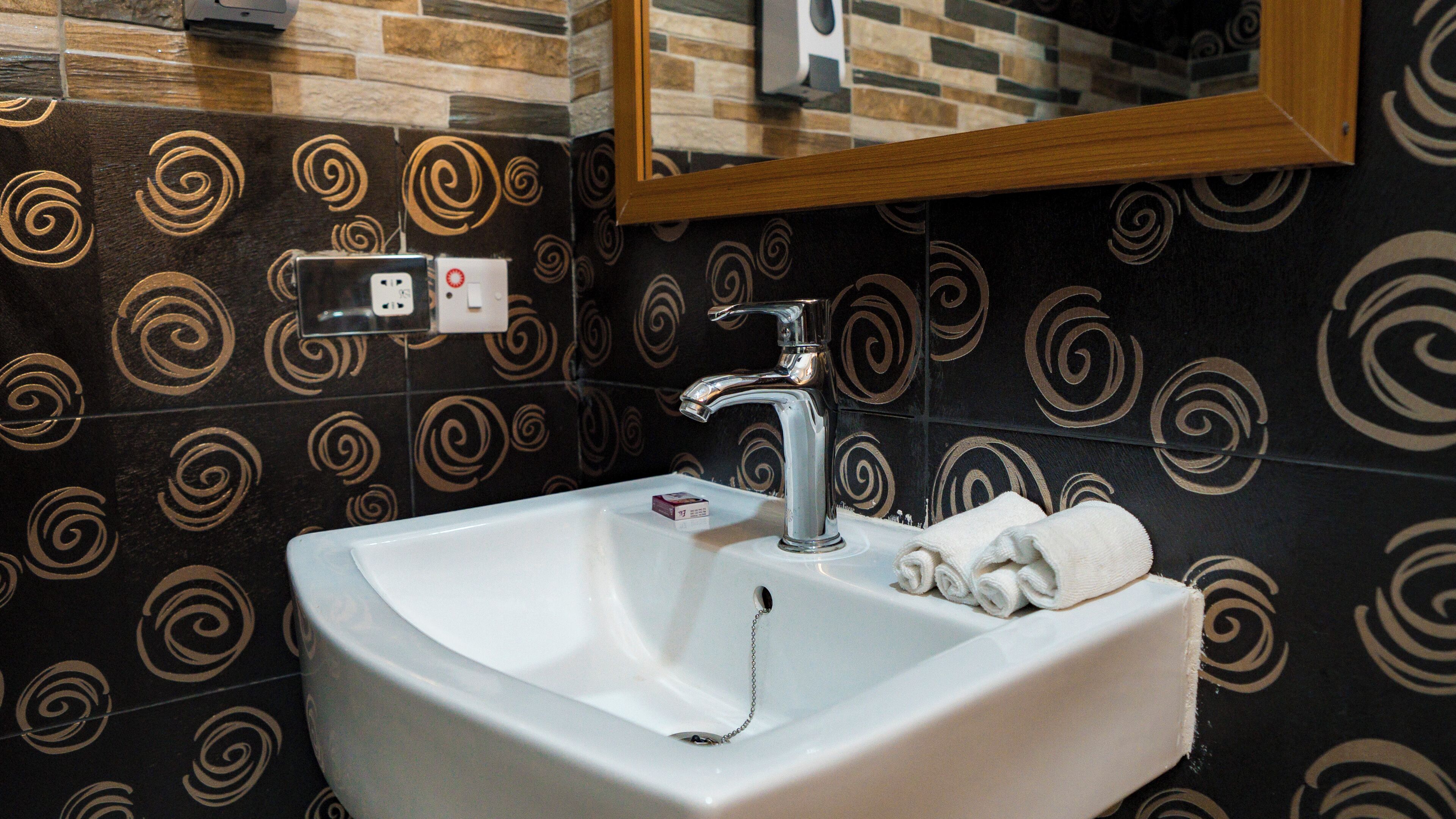 A bathroom with a white sink, a mirror, and a towel.