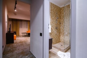 A hotel room with a shower, a small table, and a chair. - Hotel Europeca (Craiova)