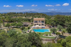 A villa with a swimming pool, surrounded by lush greenery and mountains in the background. - SON JERONIO (Muro)