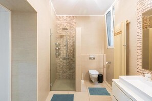Ein modernes Badezimmer mit einer Duschkabine, einer Toilette und einem Waschbecken.