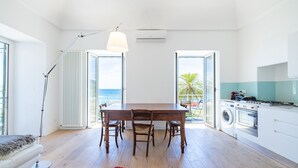 Een moderne keuken met een eethoek, grote ramen en uitzicht op de oceaan.
