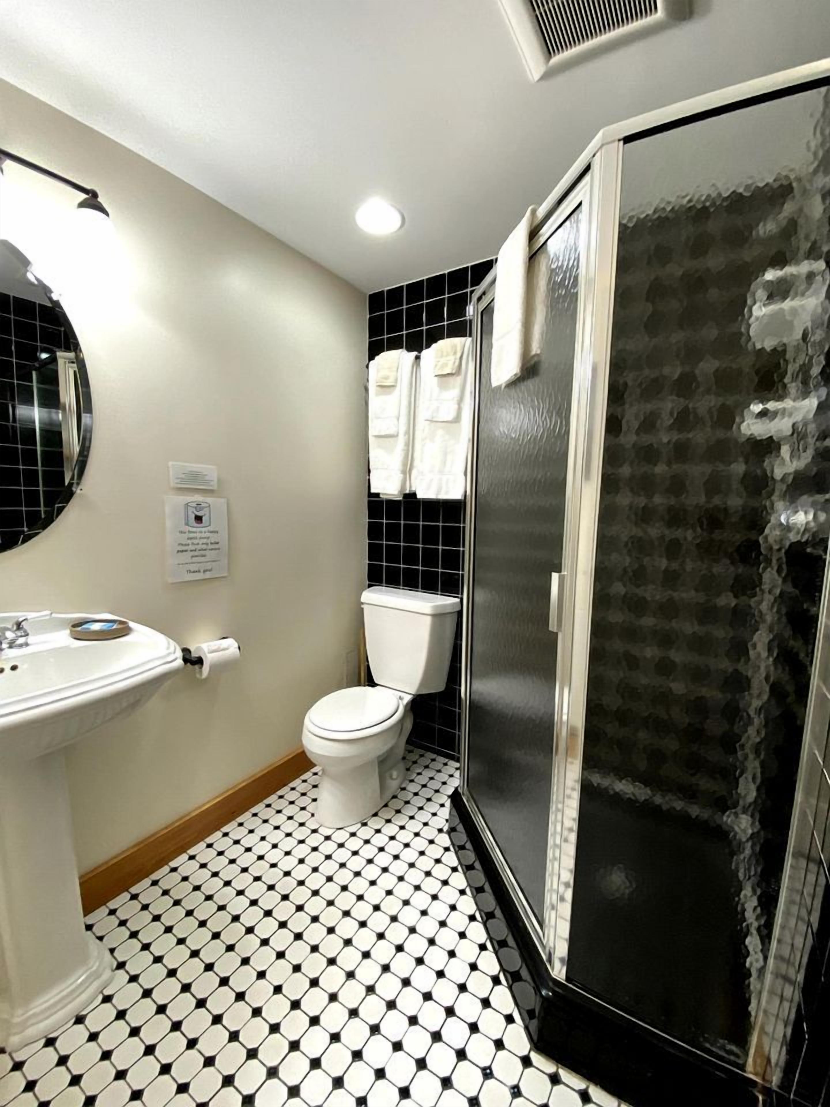 A bathroom with a toilet, sink, and shower.