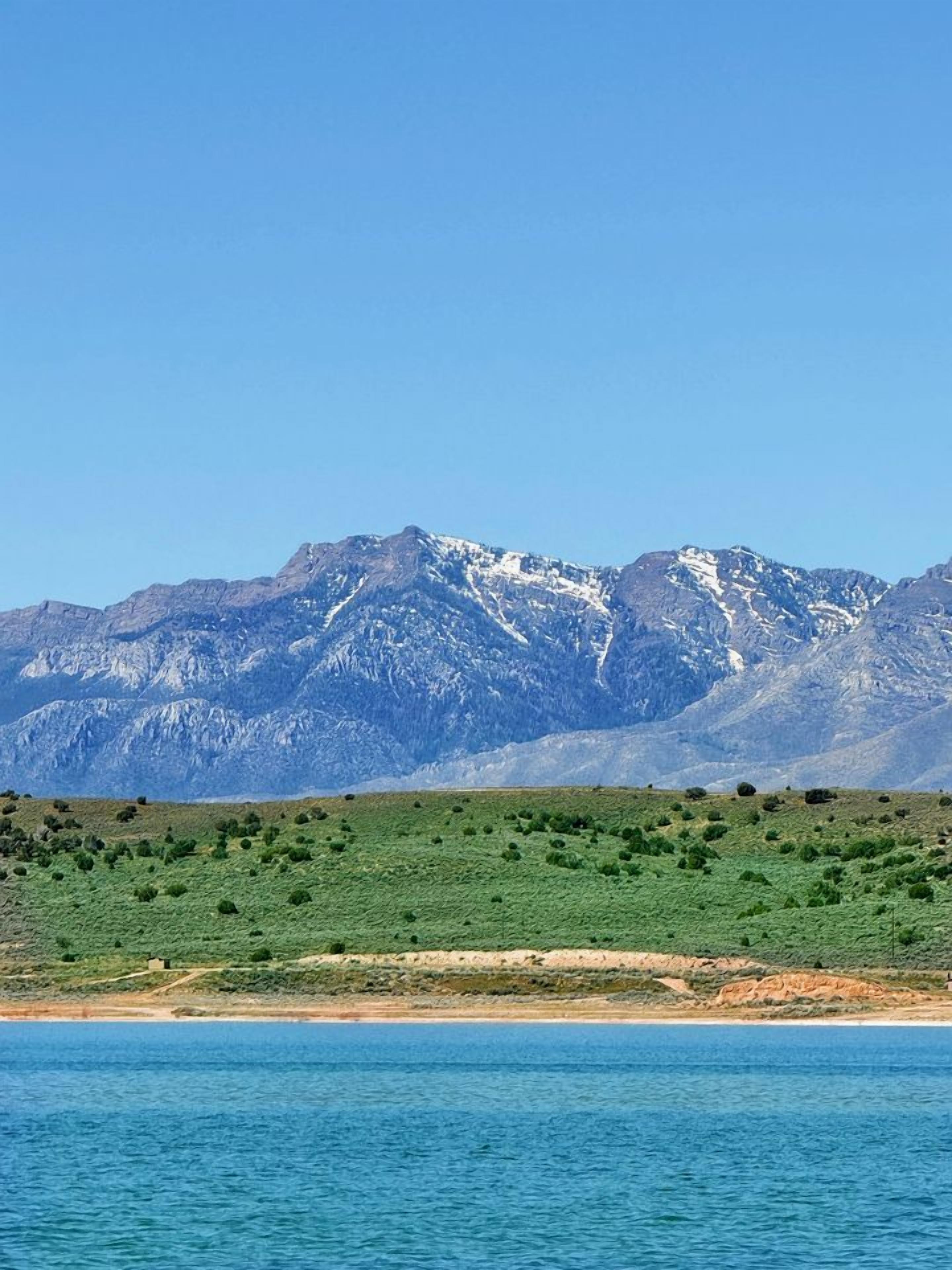 A coastal landscape with mountains in the background.
