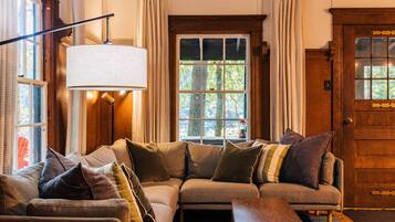 A cozy living room with a sectional sofa, a lamp, and a wooden door.