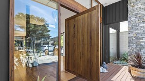 Ein modernes Interieur mit großen Glasüren, Holzboden und einer Steinswand.