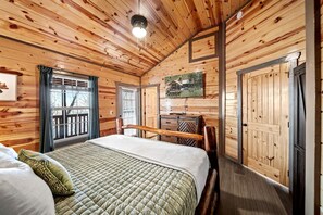A wooden cabin room with a bed, a dresser, and a painting on the wall. - Glorious Wooden Cabin with Swimming Pool in Pigeon Forge, Tennessee (Pigeon Forge)