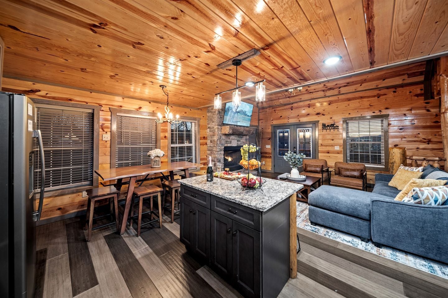 A log cabin interior with a kitchen, dining area, and living room.