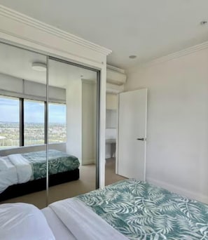 A bedroom with a bed, a wardrobe, and a door. - Sydney olympic park Free parking 08 (Sydney Olympic Park)