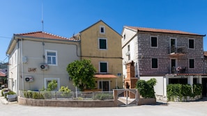 Ein zweistöckiges Gebäude mit rotem Ziegeldach, steinverkleideter Fassade und einem kleinen Balkon.