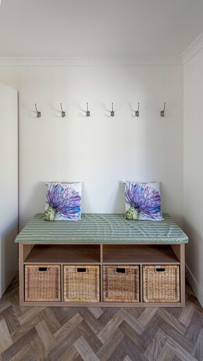 A room with a bench, two wall-mounted hooks, and three wicker baskets. - Peaceful Lake District home, near Ennerdale Water (Kirkland)