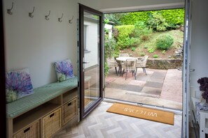 A room with a sliding glass door leading to an outdoor patio area with a table and chairs. - Peaceful Lake District home, near Ennerdale Water (Kirkland)