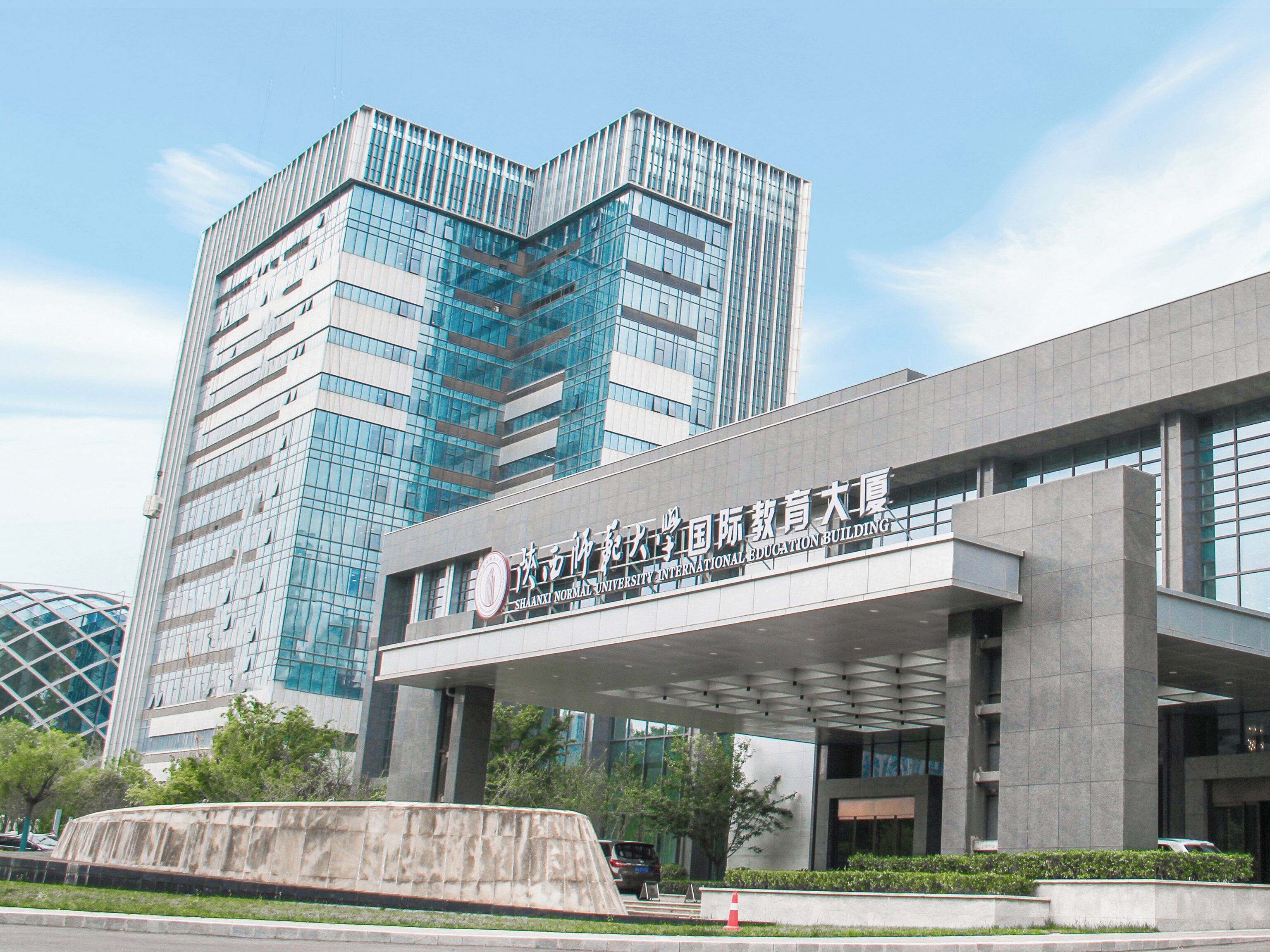 A modern building with a prominent entrance and signage indicating it is an educational institution.