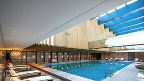 A modern indoor swimming pool with lounge chairs and a contemporary design. - Shaanxi Normal University International Education Building (Xi'an)