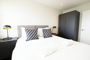 A hotel room with a bed, two bedside tables, a wardrobe, and a nightstand. - Church House by Guestz (Filton)