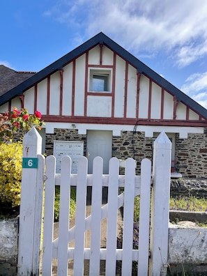 A traditional building with a stone facade, a white picket fence, and a small window. - Studio 200m from Les Rosaires Beach (Plérin)