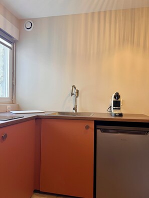 A kitchen with a sink, a dishwasher, and a window. - Studio 200m from Les Rosaires Beach (Plérin)