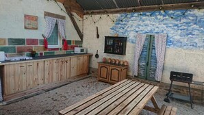 Una cocina rústica con armarios de madera, una mesa de madera y un mural decorativo.