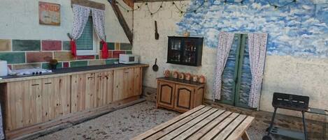Eine rustikale Küche mit Holzausbau, einem Holztisch und einer dekorativen Wandmalerei.